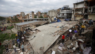 People gather near a collapsed house after a major earthquake in Kathmandu, Nepal April 25, 2015. A shallow earthquake measuring 7.9 magnitude struck west of the ancient Nepali capital of Kathmandu on Saturday, killing more than 100 people, injuring hundreds and leaving a pall over the valley, doctors and witnesses said.  REUTERS/Navesh Chitrakar      TPX IMAGES OF THE DAY      - RTX1A7LL